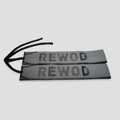 Two 'REWOD' labels on a blurred gym background with ropes.