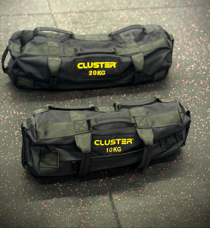 Two black sandbags with yellow text on a gray floor.
