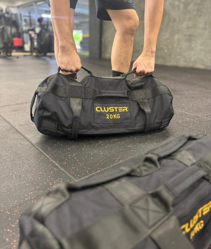 Person holding a 20kg Cluster Sandbag in a gym setting