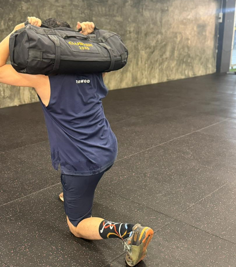 Person performing 20kg sand bag Lunges gym setting