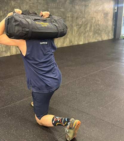 Person performing 20kg sand bag Lunges gym setting